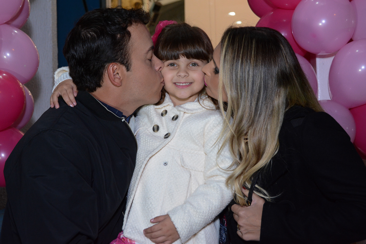 Fotografia da aniversariante com os pais no arco de bexiga Buffet Comics São Paulo SP