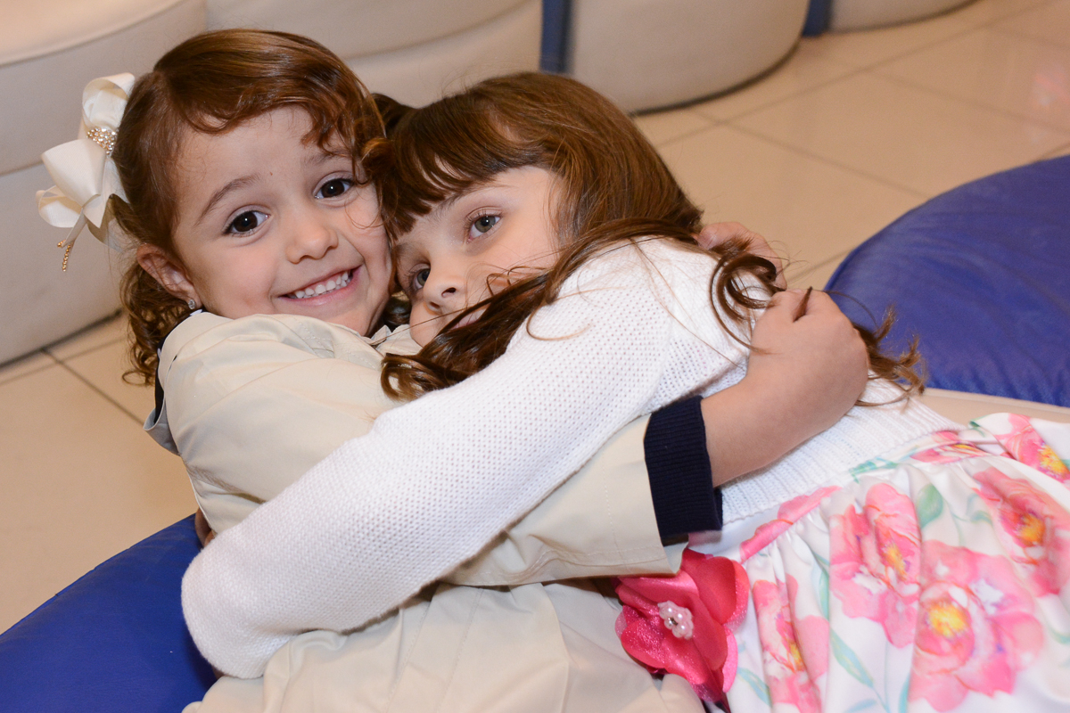 Fotografia da aniversariante abraçando amiguinha Buffet Comics São Paulo SP