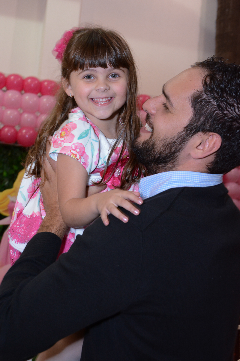 Fotografia da aniversariante no colo padrinho Buffet Comics São Paulo SP