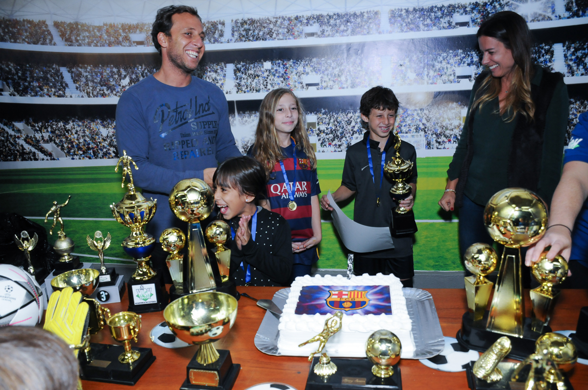 Fotografia do aniversariante e amigos na mesa do bolo do Buffet High Soccer