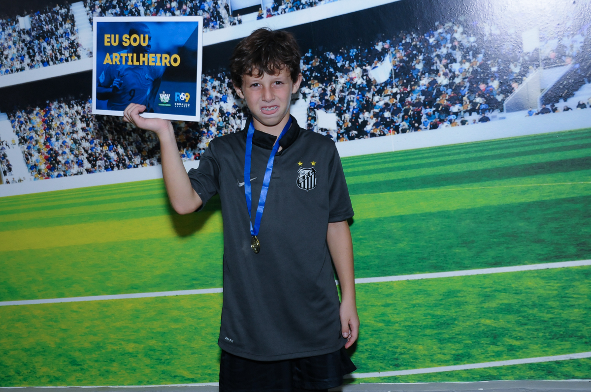 Fotografia do aniversariante no campo de futebol com a medalha no Buffet High Soccer