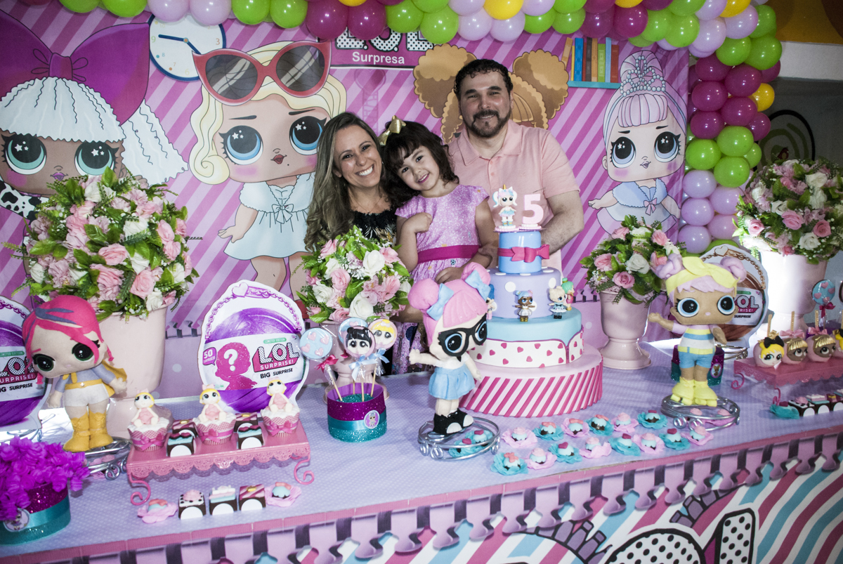 A tradicional foto da aniversariante com os pais na mesa temática