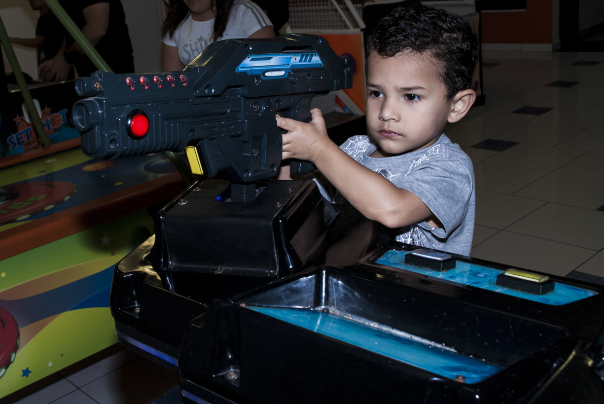 O amigo brinca no simulador de tiro