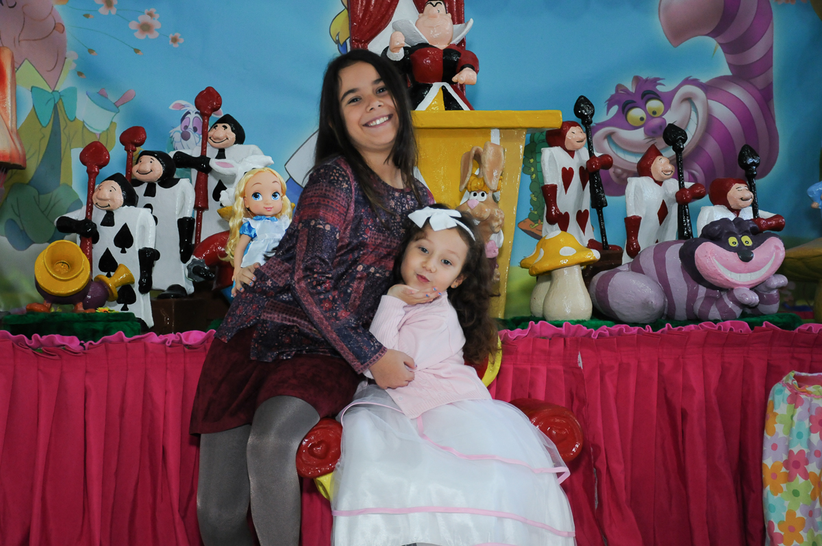 Foto da aniversariante e irmã na mesa Alice no País das Maravilhas no Buffet Magic Joy