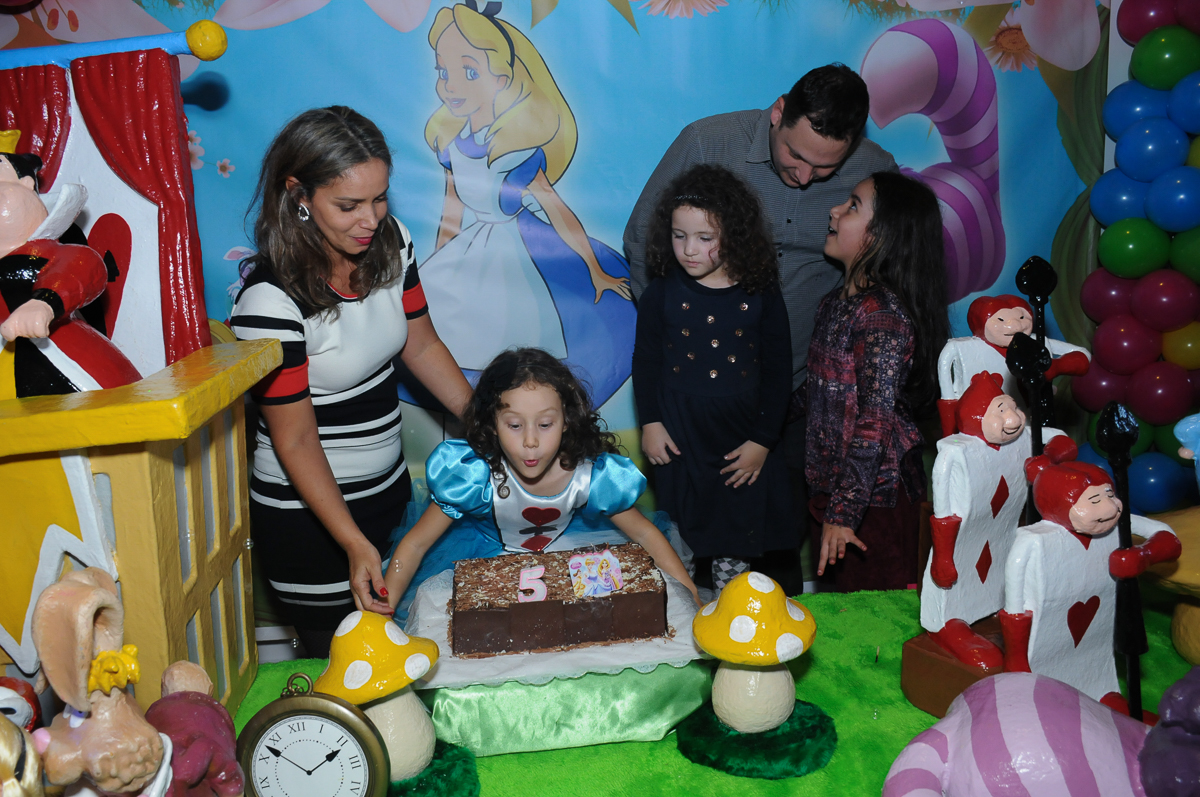 Fotografia da aniversariante soprando a velinha do bolo no Buffet Magic Joy