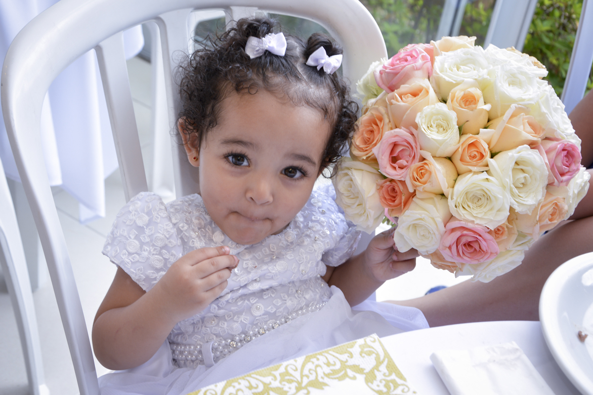 a daminha segura o buquet da noiva