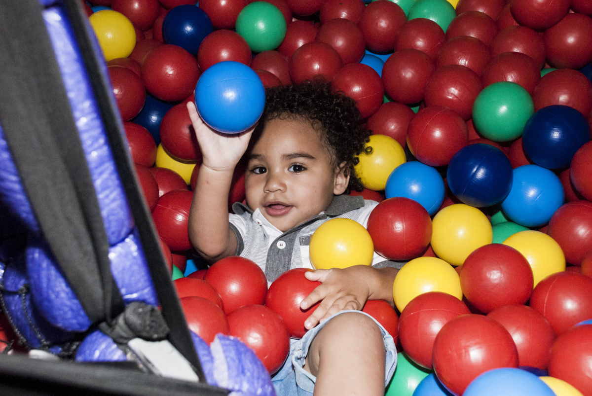 feliz mergulhando nas bolinhas coloridas