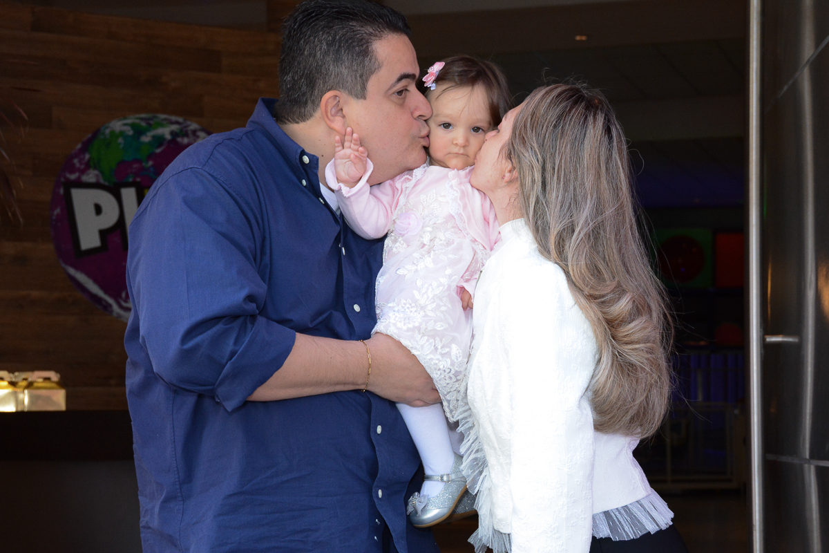 Lorena sendo beijada pelo papai e mamãe no Buffet Planeta Kids, São Paulo - SP