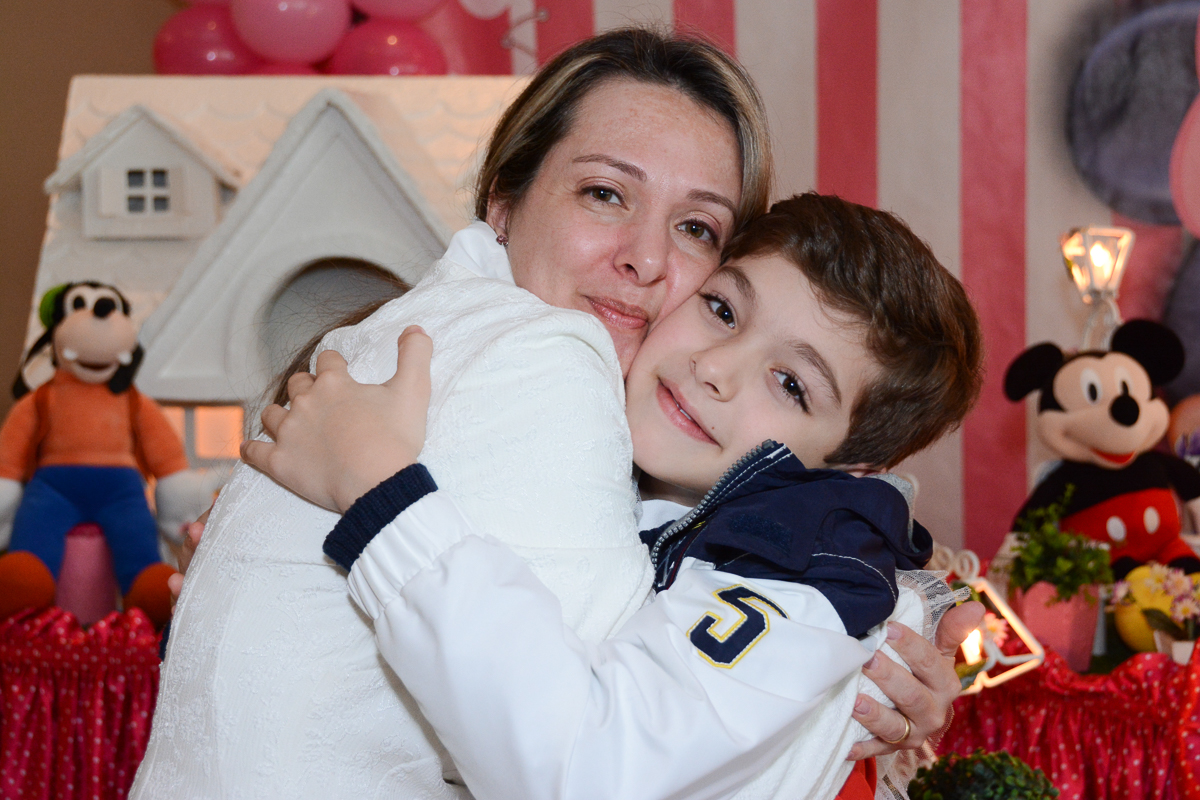 Mamãe de rostinho colado com o irmãozinho da Lorena em frente a mesa decorada  no Buffet Planeta Kids, São Paulo - SP