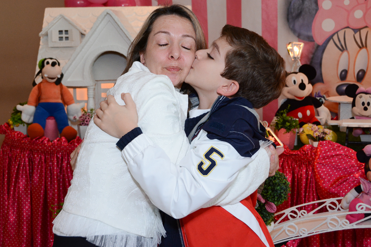 Irmãozinho de Lorena beijando a mamãe em frente a mesa decorada  no Buffet Planeta Kids, São Paulo - SP