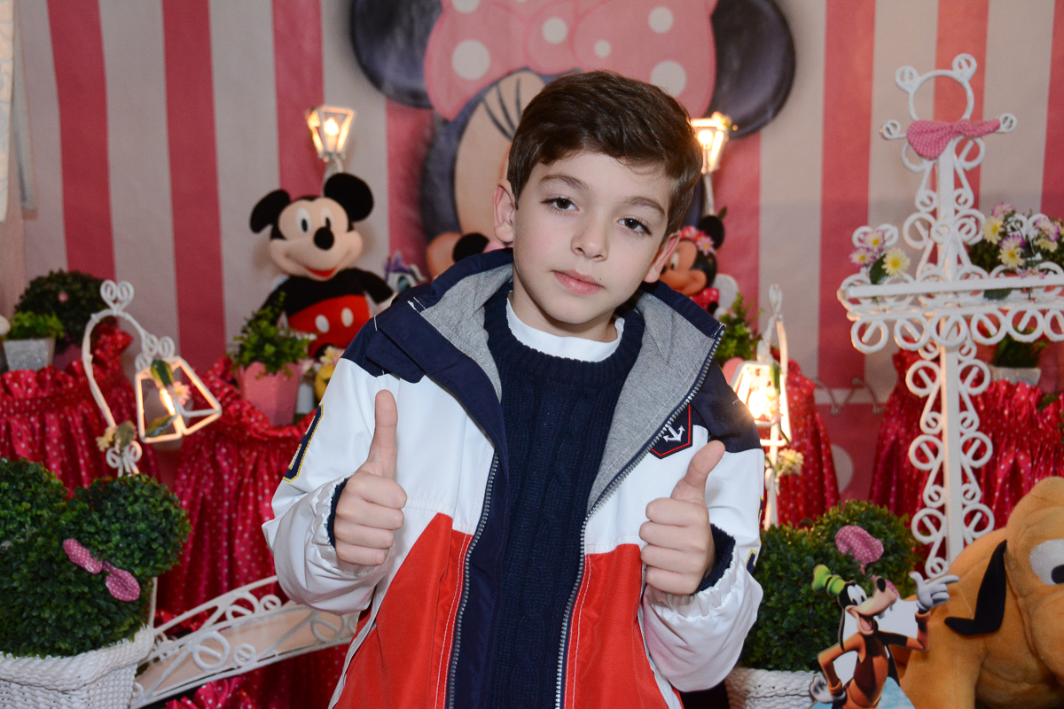 O irmãozinho de Lorena em frente a mesa decorada  no Buffet Planeta Kids, São Paulo - SP