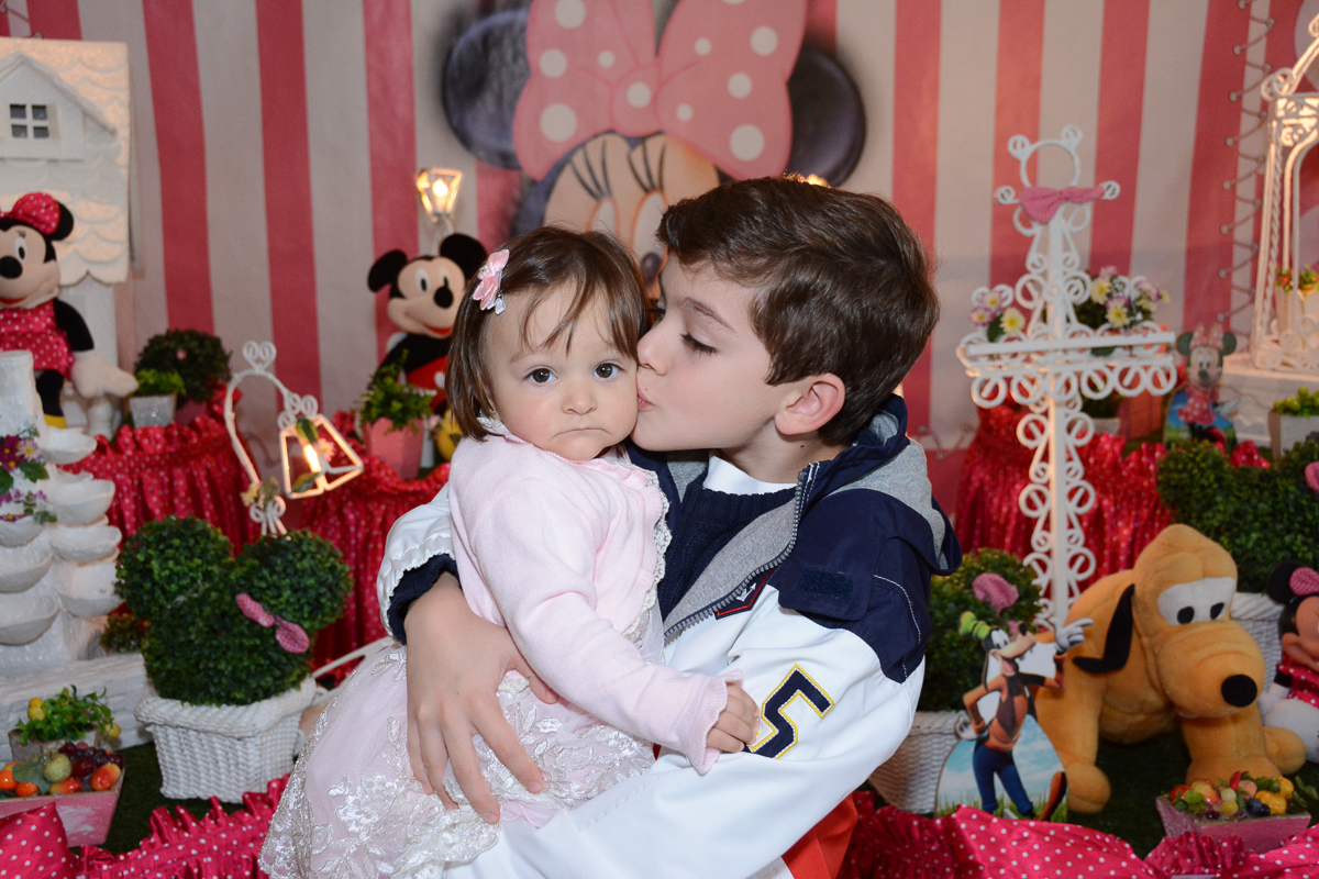 Irmão de Lorena a beija em  frente a mesa decorada   no Buffet Planeta Kids, São Paulo - SP