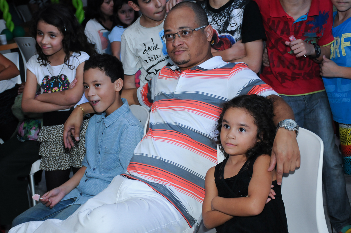 Gabriel, Anna e o papai assistindo a retrospectiva  Buffet Zureta-Osasco -SP