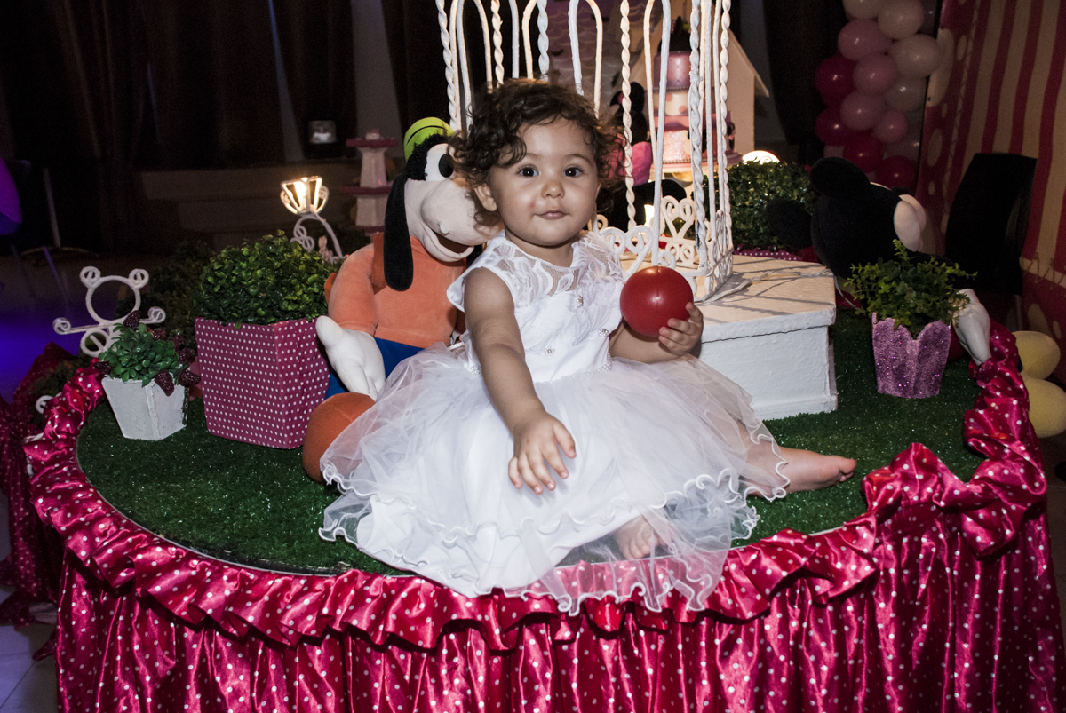 sentada na mesa no meio dos  personagens da mesa