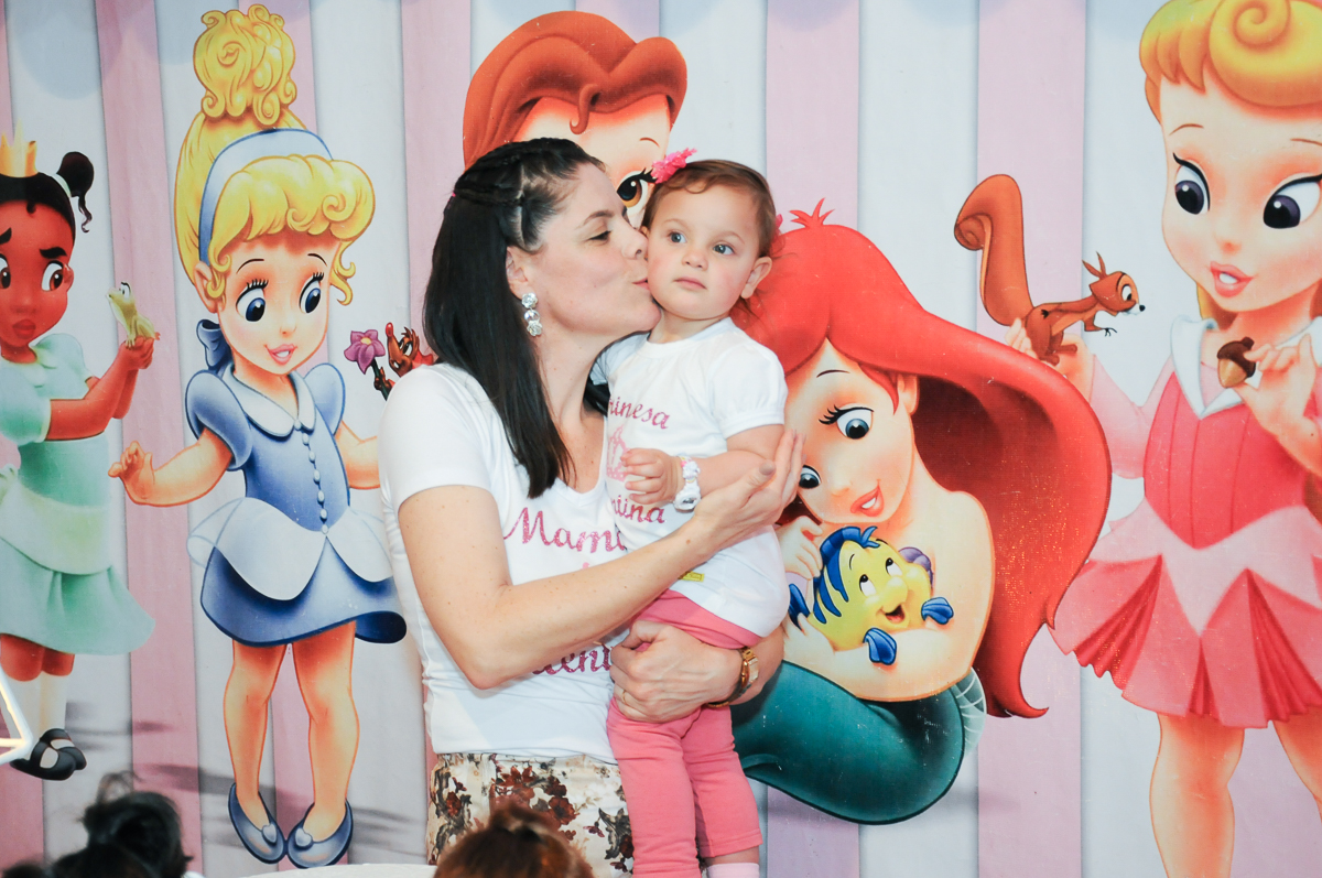 mamãe beijando a valentina em frente a mesa decorada no Buffet Fábrica da Alegria