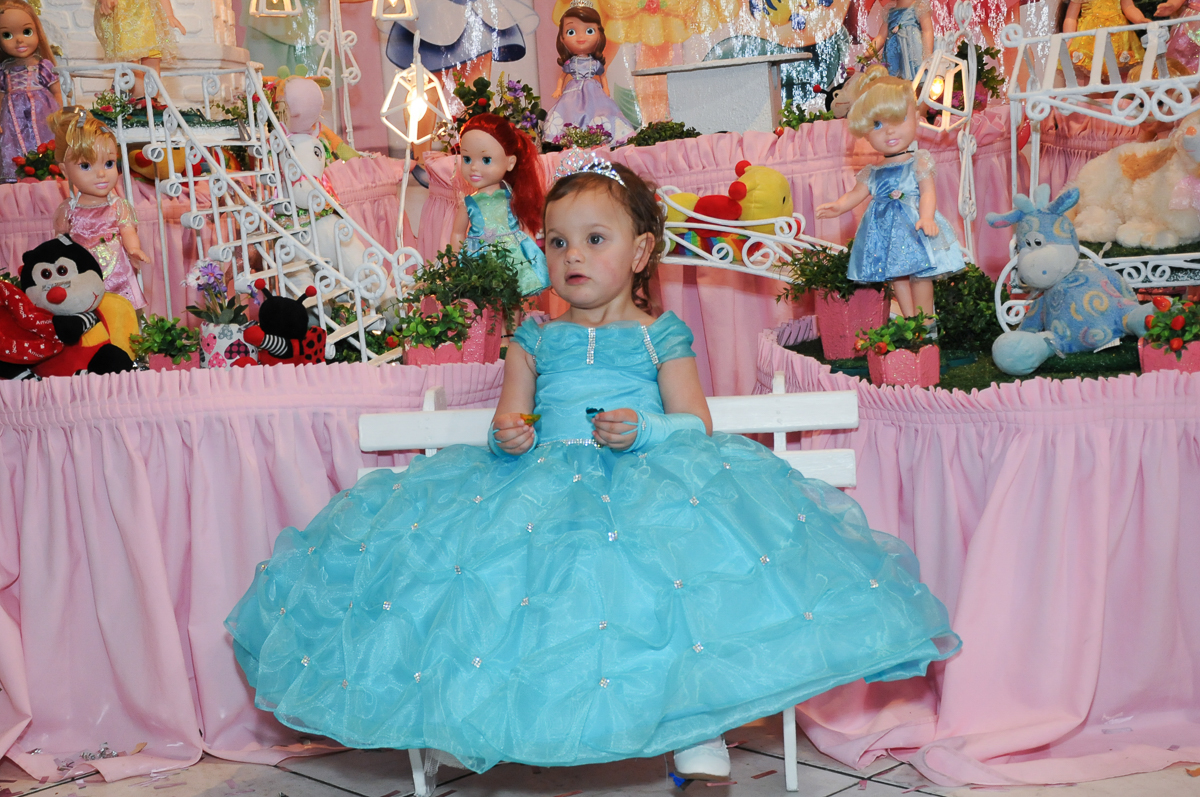 valentina vestida de princesa em frente a mesa do parabéns