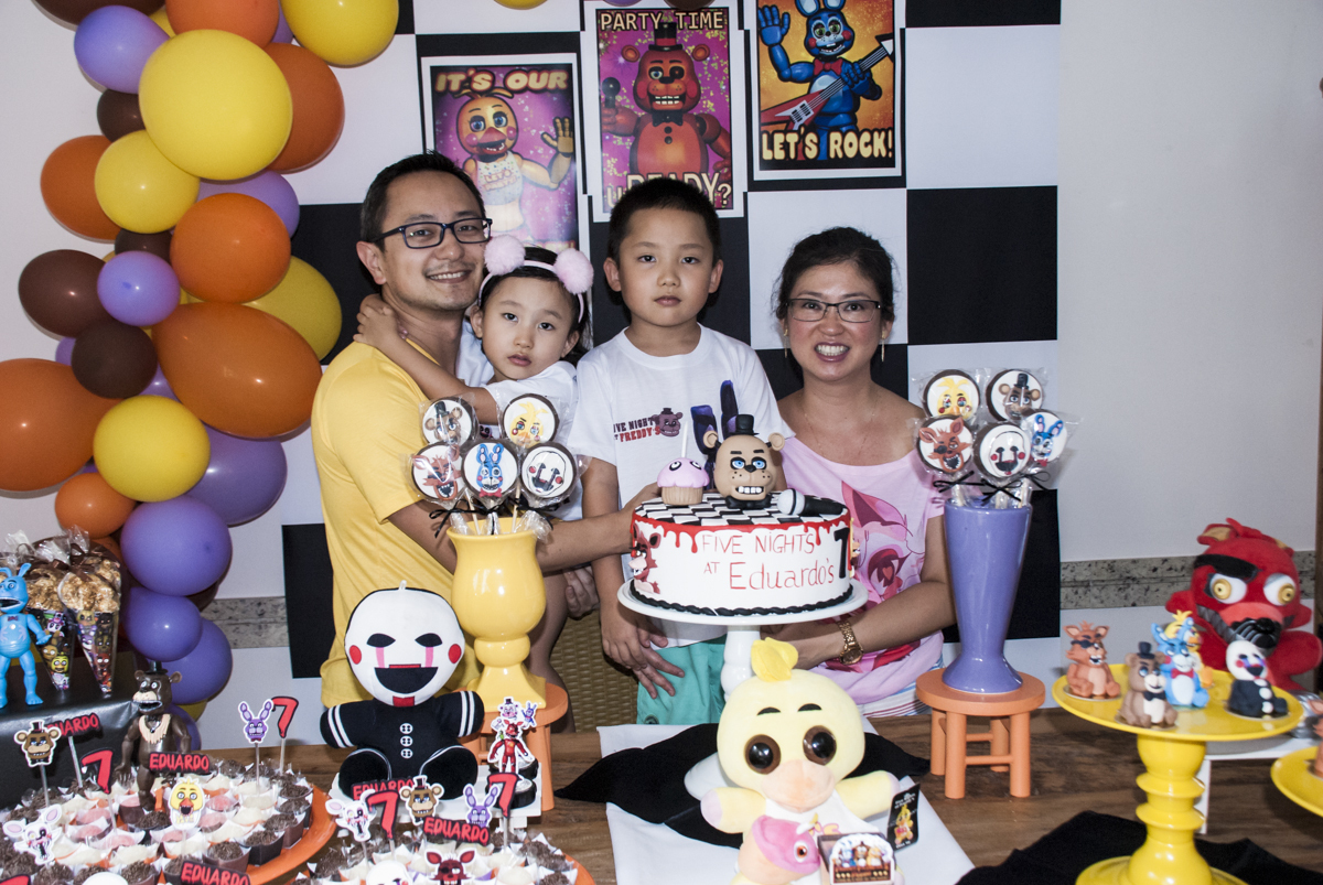 família sendo fotografada na mesa temática