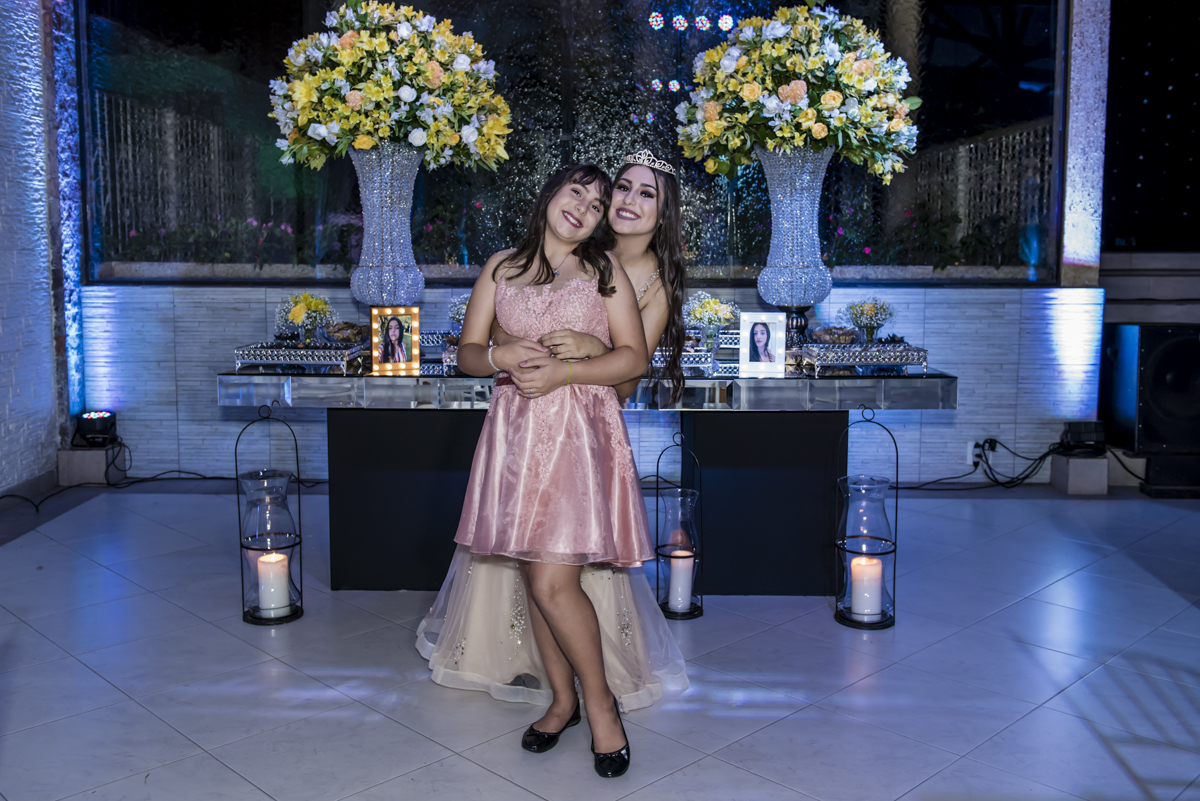 As irmãs fazem a foto em frente a mesa