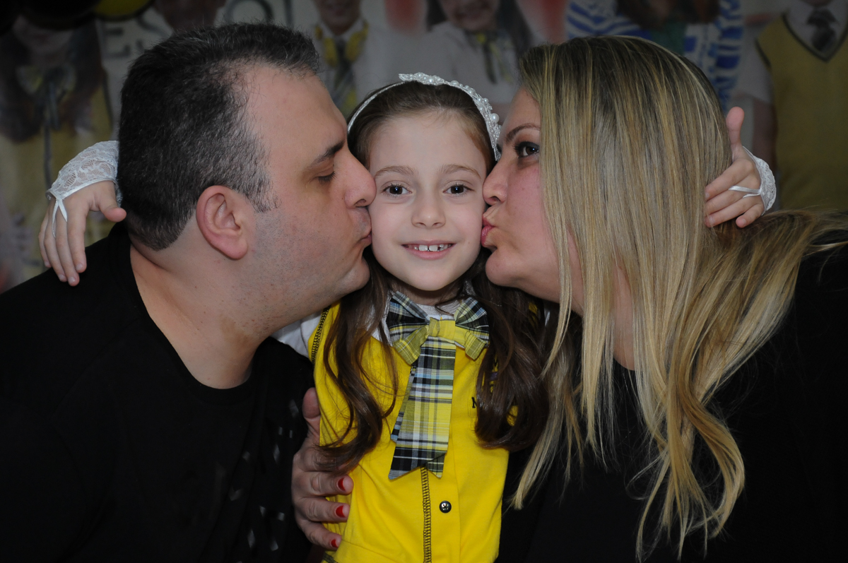 Lara ganhando beijinho dos pais no Buffet Zezé e Lelé