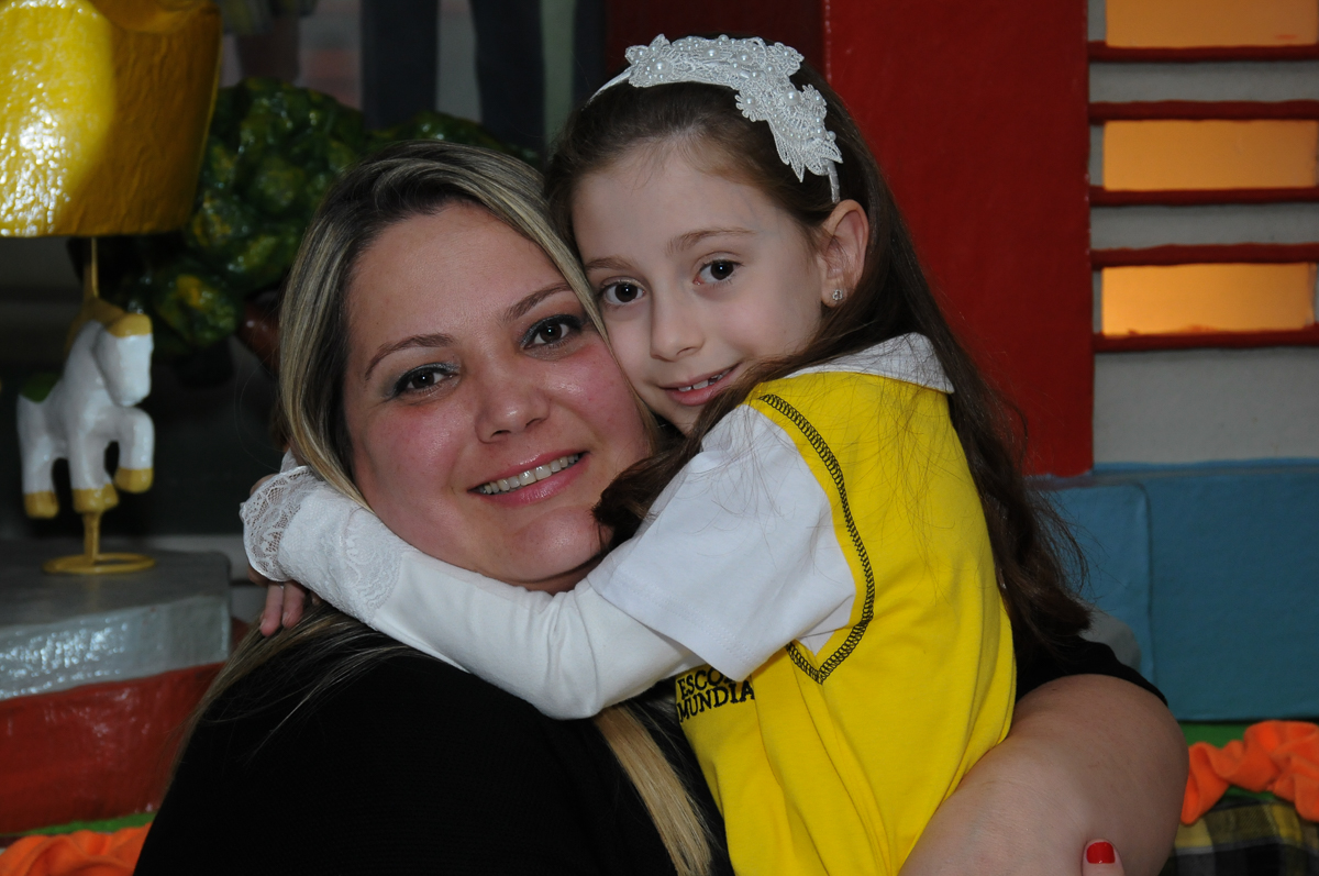 Lara com a mamãe em frente a mesa decorada carrossel no Buffet Zezé e Lelé
