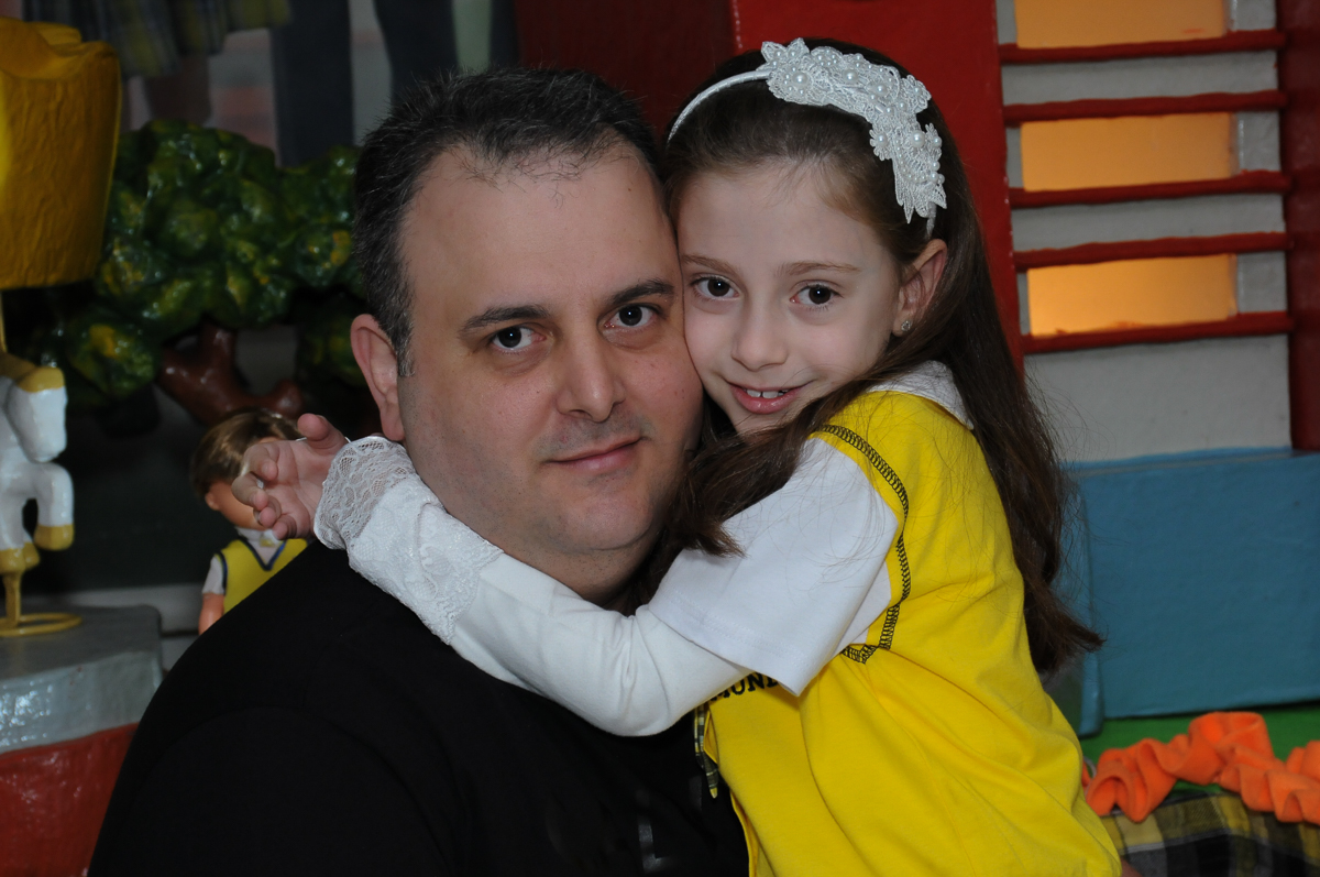 Lara com o papai em frente a mesa decorada do carrossel no Buffet Zezé e Lelé