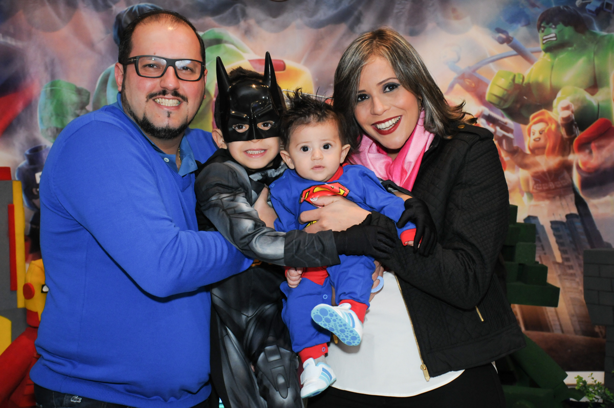 matheus com o irmãozinho e seus pais em frente a mesa decorada lego no buffet fábrica da alegria, osasco