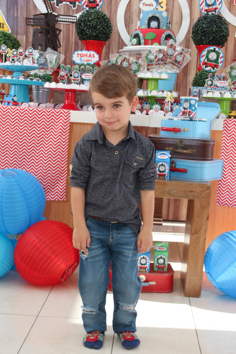 tomás em frente a mesa decorada do tomas na Festa no condomínio em São Paulo