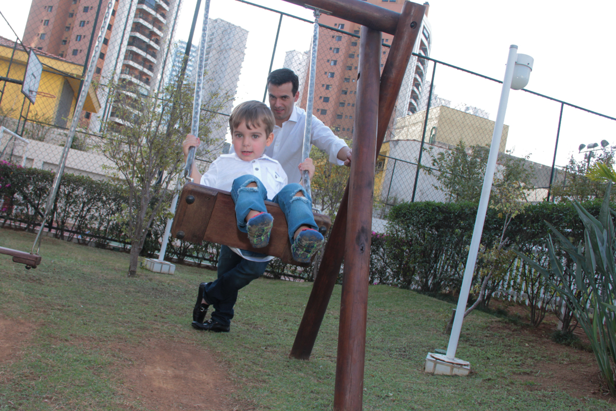 papai brincando com tomás no play ground na Festa no condomínio em São Paulo