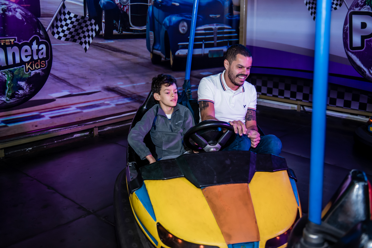 pai e filho se diverte no carrinho de trombada