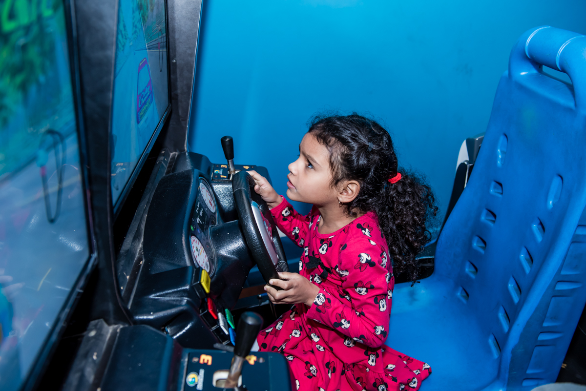 a aniversariante brinca no simulador de corridas