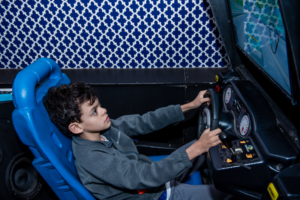 o irmão também se diverte no simulador de corridas