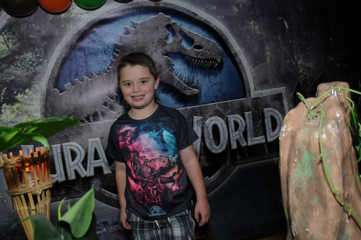 thiago em frente a mesa decorada dinossauros no buffet espaço boo, Lapa, São Paulo