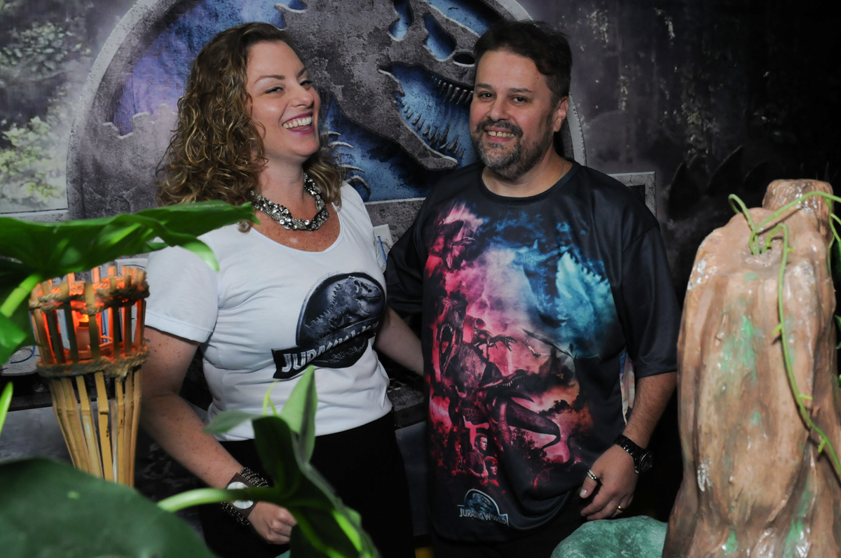 papai e mamãe felizes na festa do thiiago em frente a mesa decorada dos dinossauros no buffet espaço boo, Lapa, São Paulo