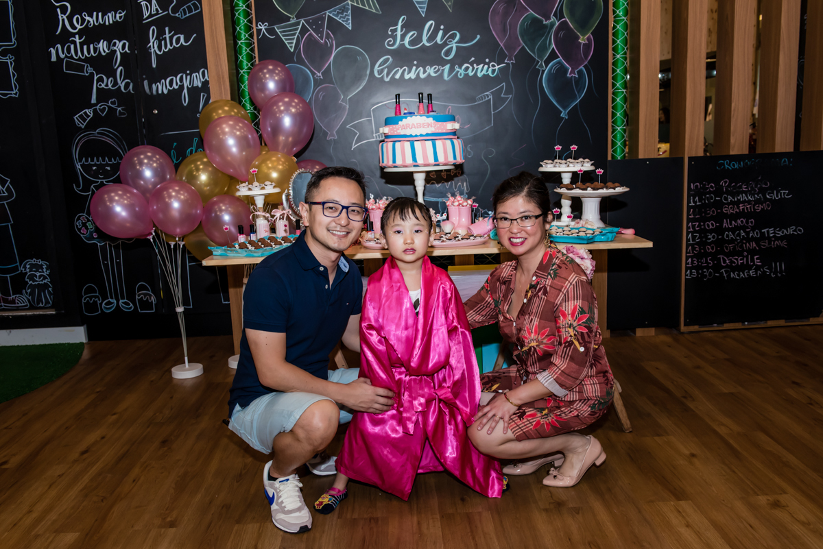 a família é fotografada na mesa do bolo