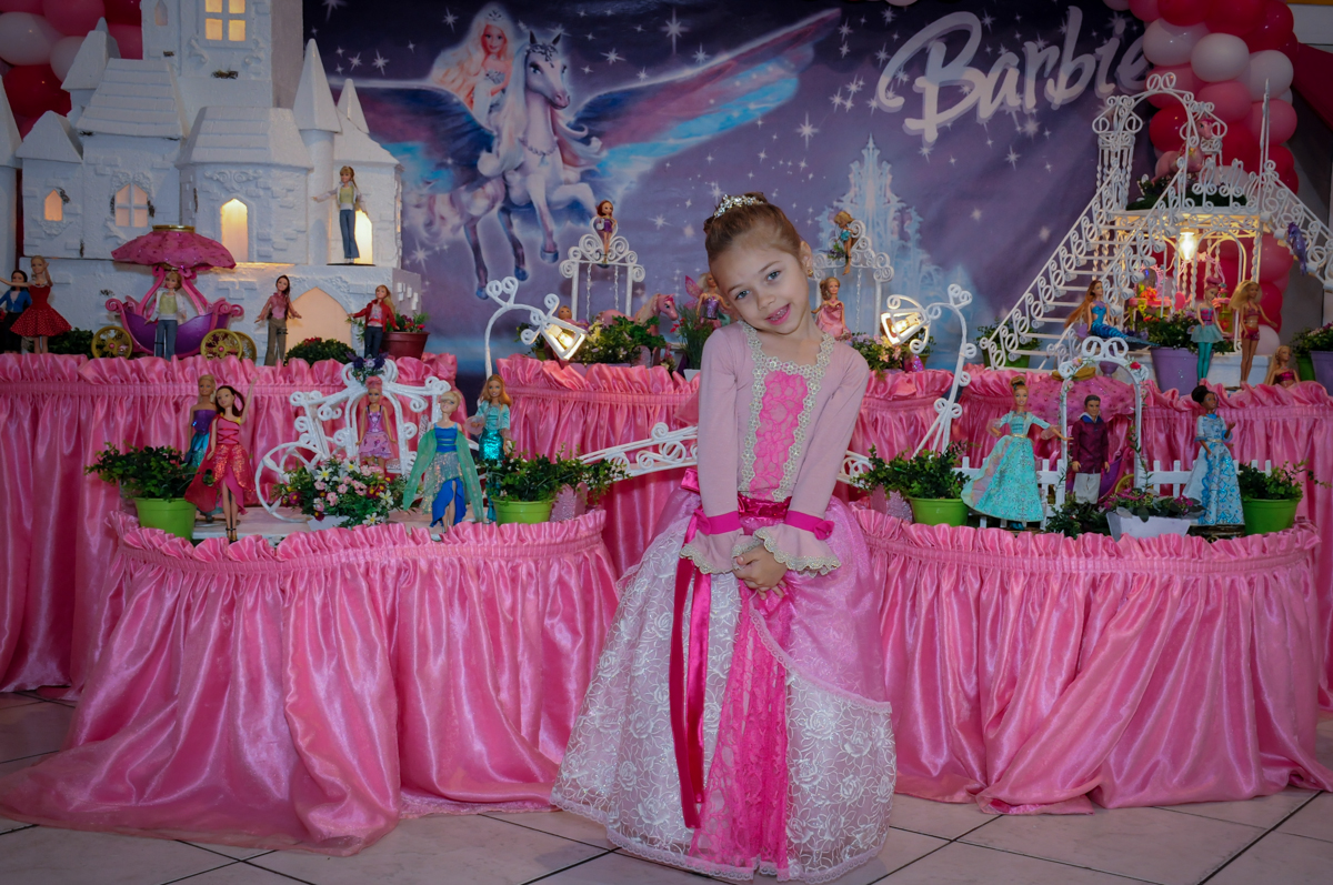 sophia em frente a mesa decorada da barbie no Buffet Fábrica da Alegria, Unidade Osasco