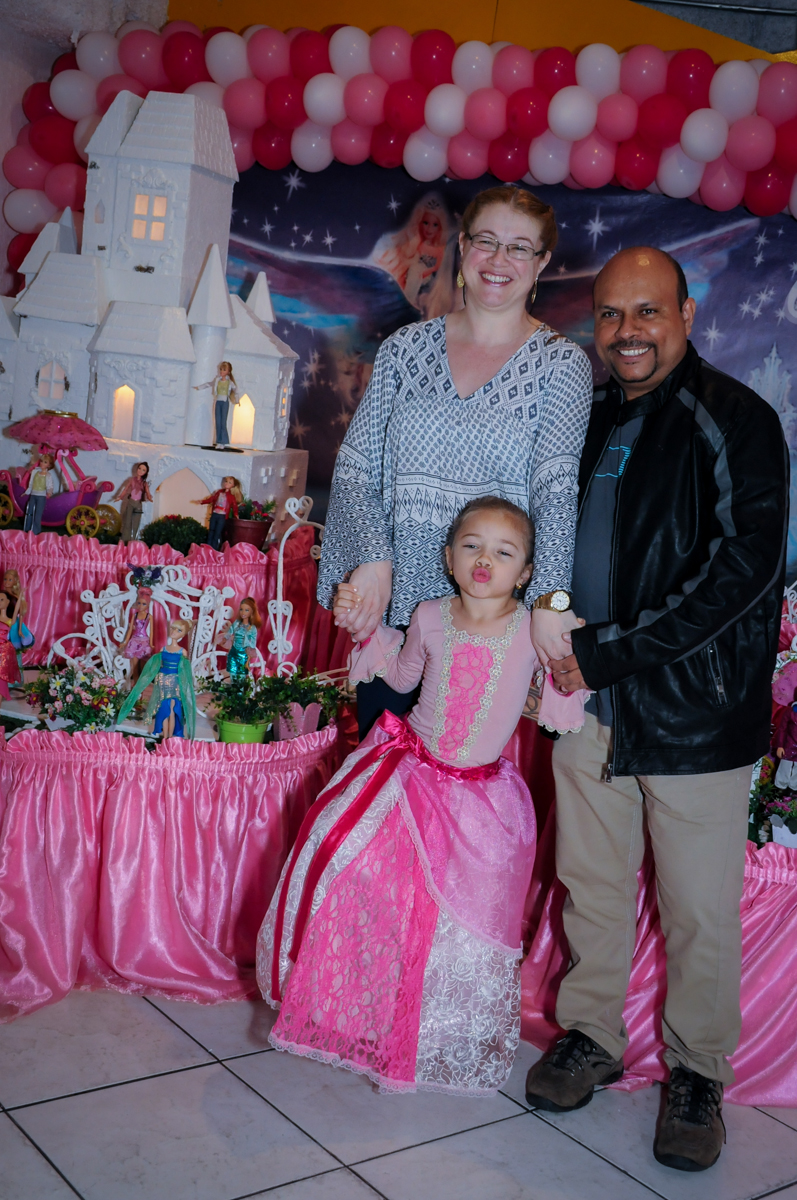 foto da aniversariante dom os pais em frente a mesa decorada barbie no Buffet Fábrica da Alegria, Unidade Osasco