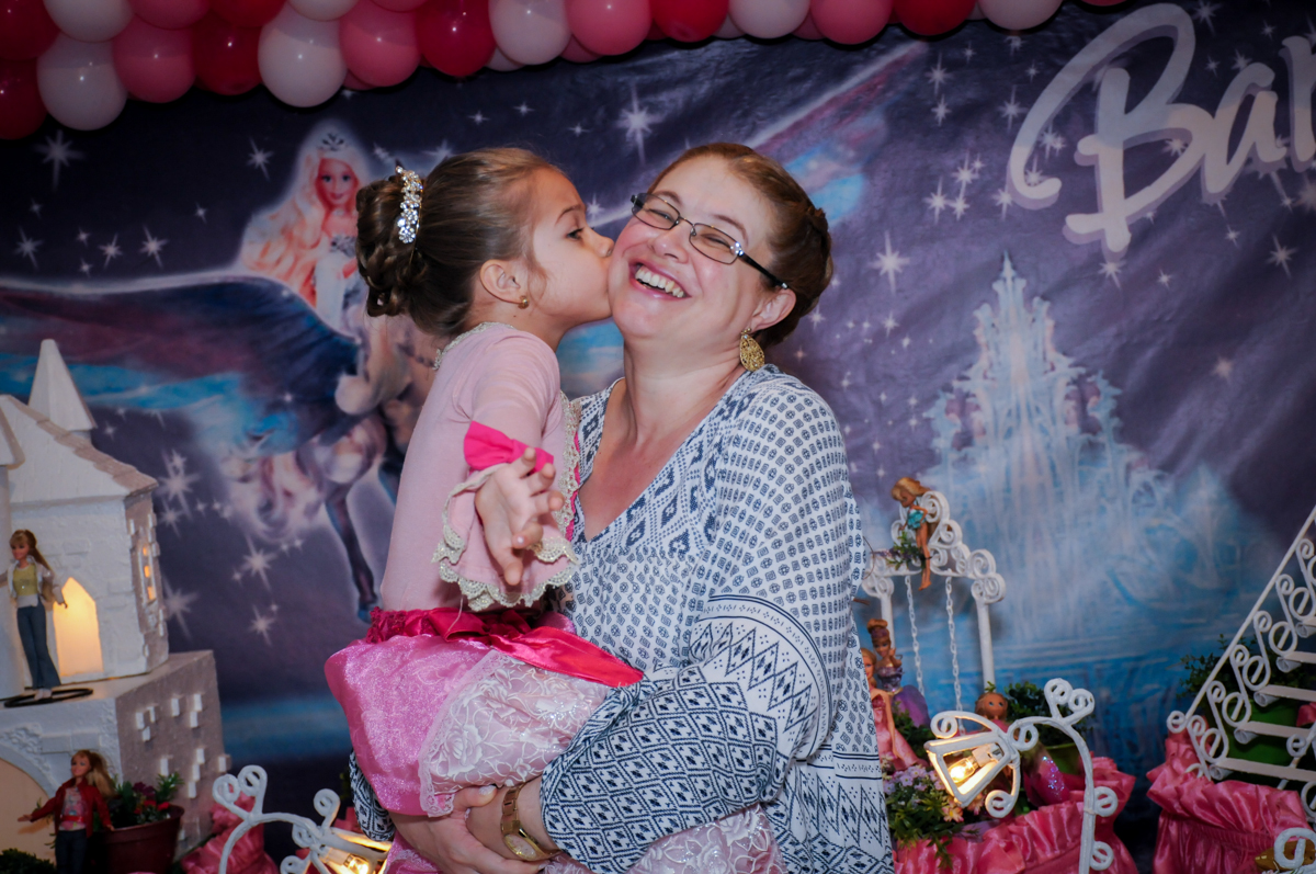 beijo da aniversariante em sua mãe em frente a mesa decorada barbie no Buffet Fábrica da Alegria, Unidade Osasco