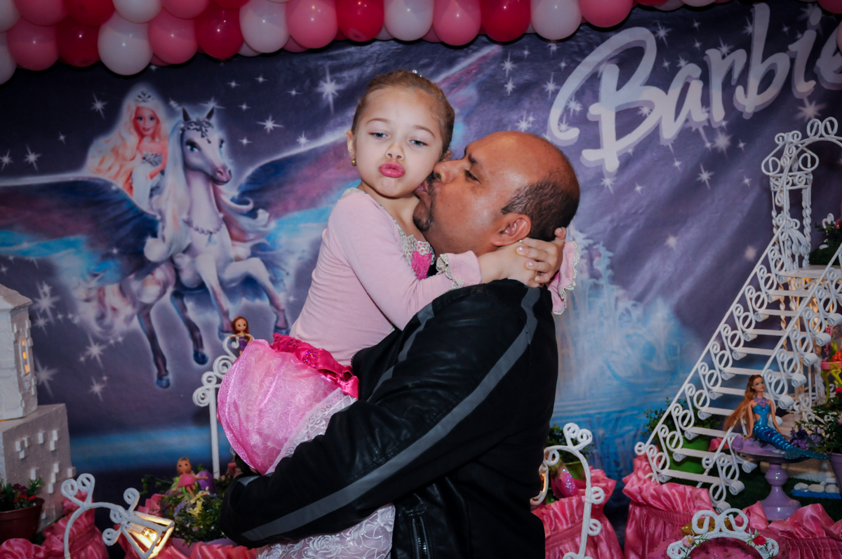 beijo do papai na aniversariante em frente a mesa decorada barbie no Buffet Fábrica da Alegria, Unidade Osasco