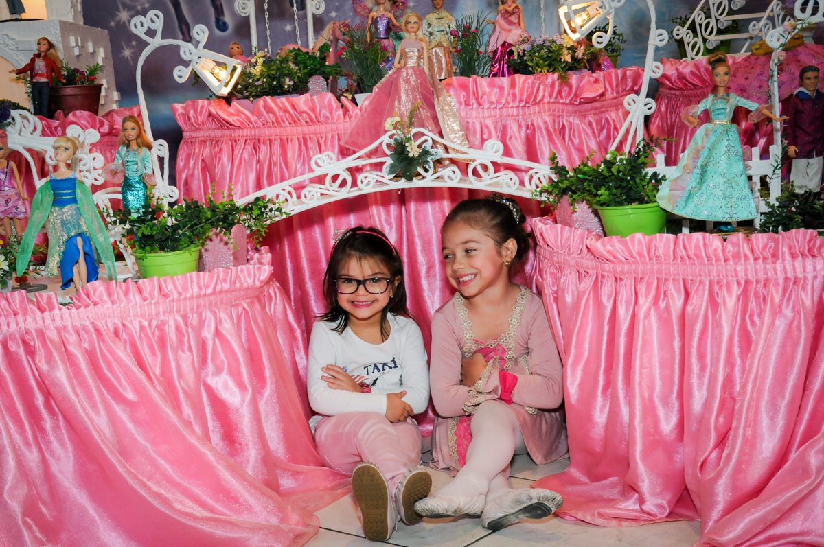 aniversariante e amiguinha em frente a mesa decorada barbie no Buffet Fábrica da Alegria, Unidade Osasco
