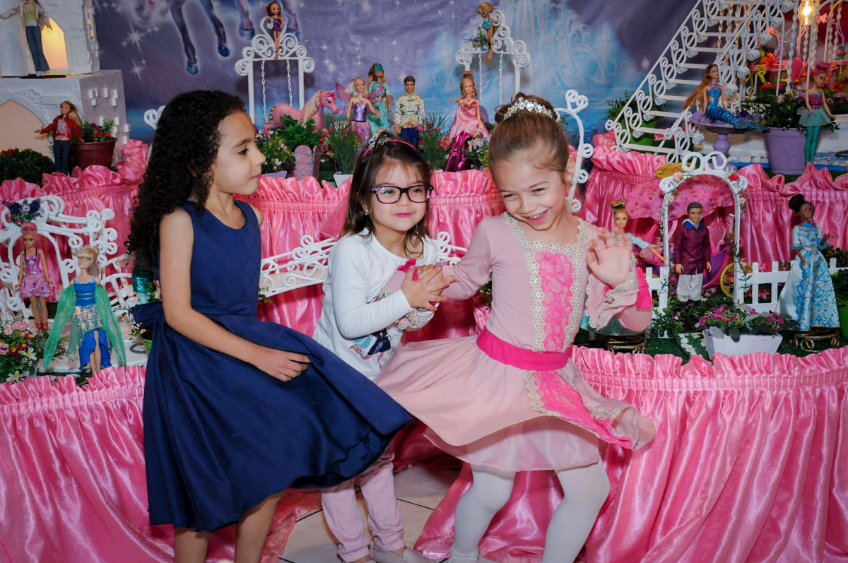 risadas da aniversariante e amigas em frente a mesa decorada barbie no Buffet Fábrica da Alegria, Unidade Osasco