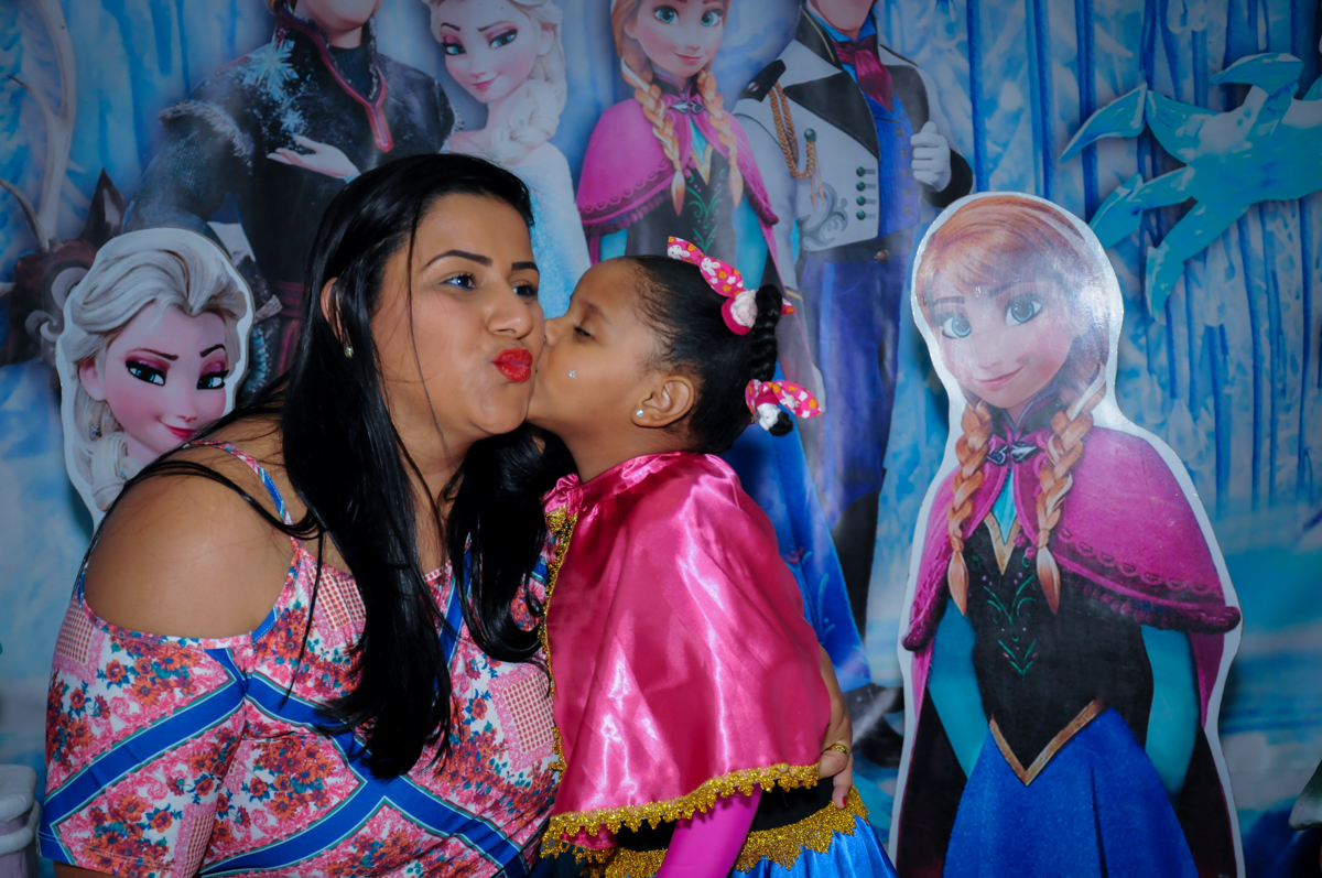 beijinho da aniversariante em sua mãe em frente a mesa frozen no Buffet Magic Joy Unidade Saude
