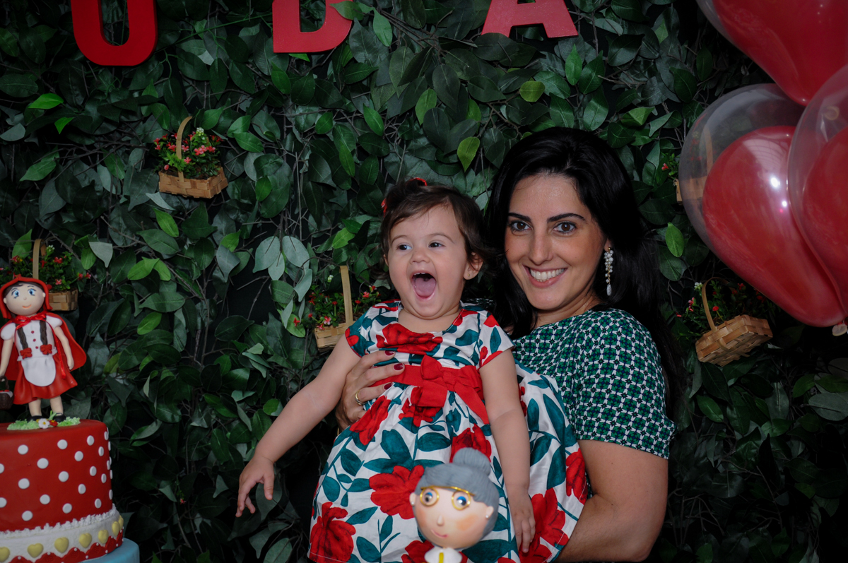 alegria da aniversariante e de sua mãe atras da mesa tema chapeuzinho vermelho no buffet spazio reale, são paulo-sp