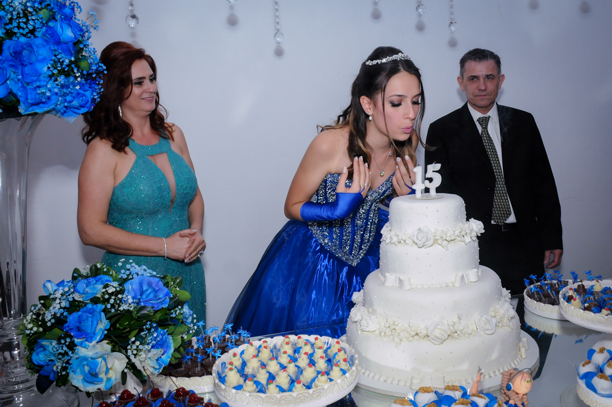 aniversariante sopra a velinha do bolo de aniversário de 15 anos no Buffet Marília's São Paulo