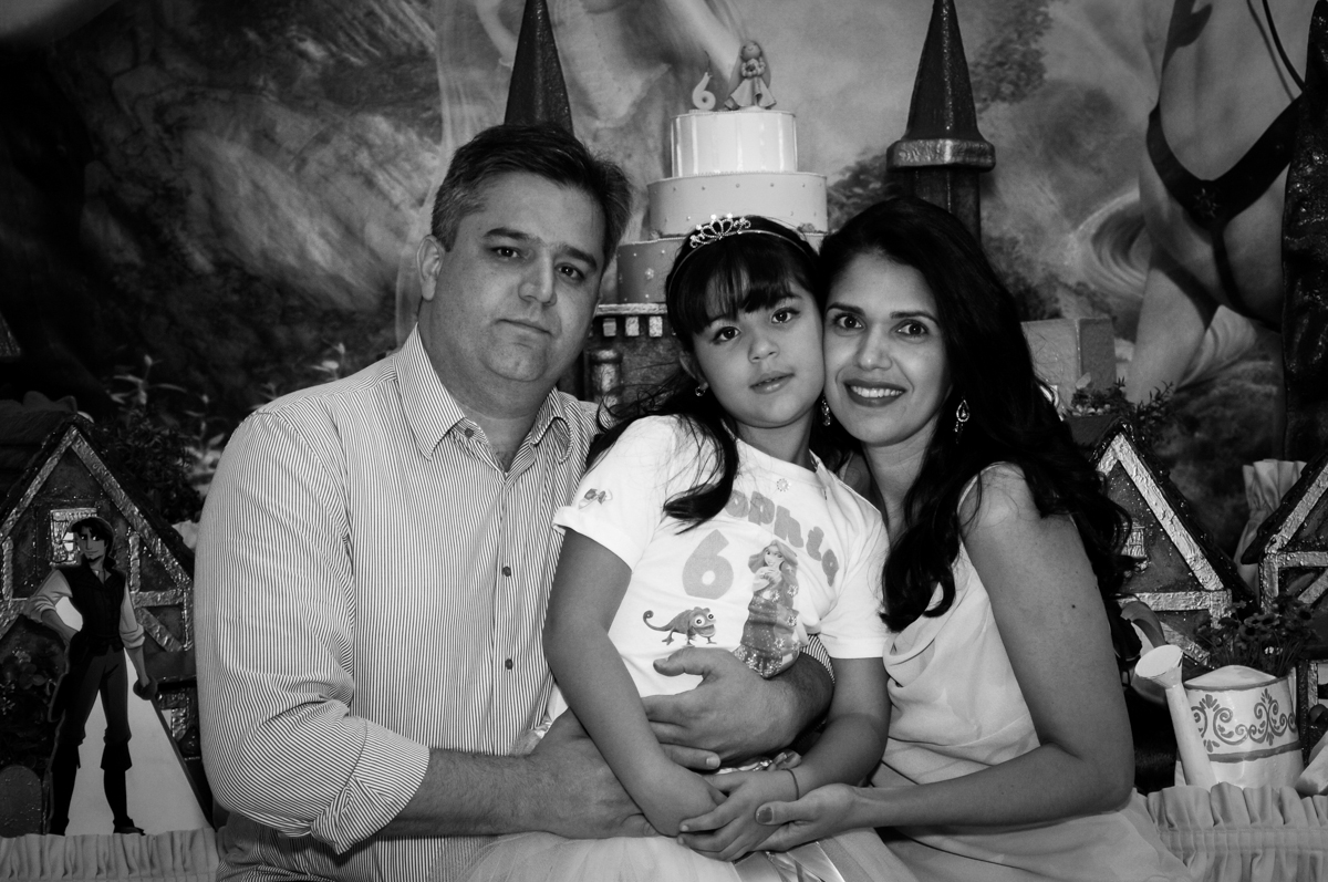 foto dos pais com a aniversariante em frente a mesa tema rapunzel no Buffet Fábrica da Alegria Osasco, São Paulo