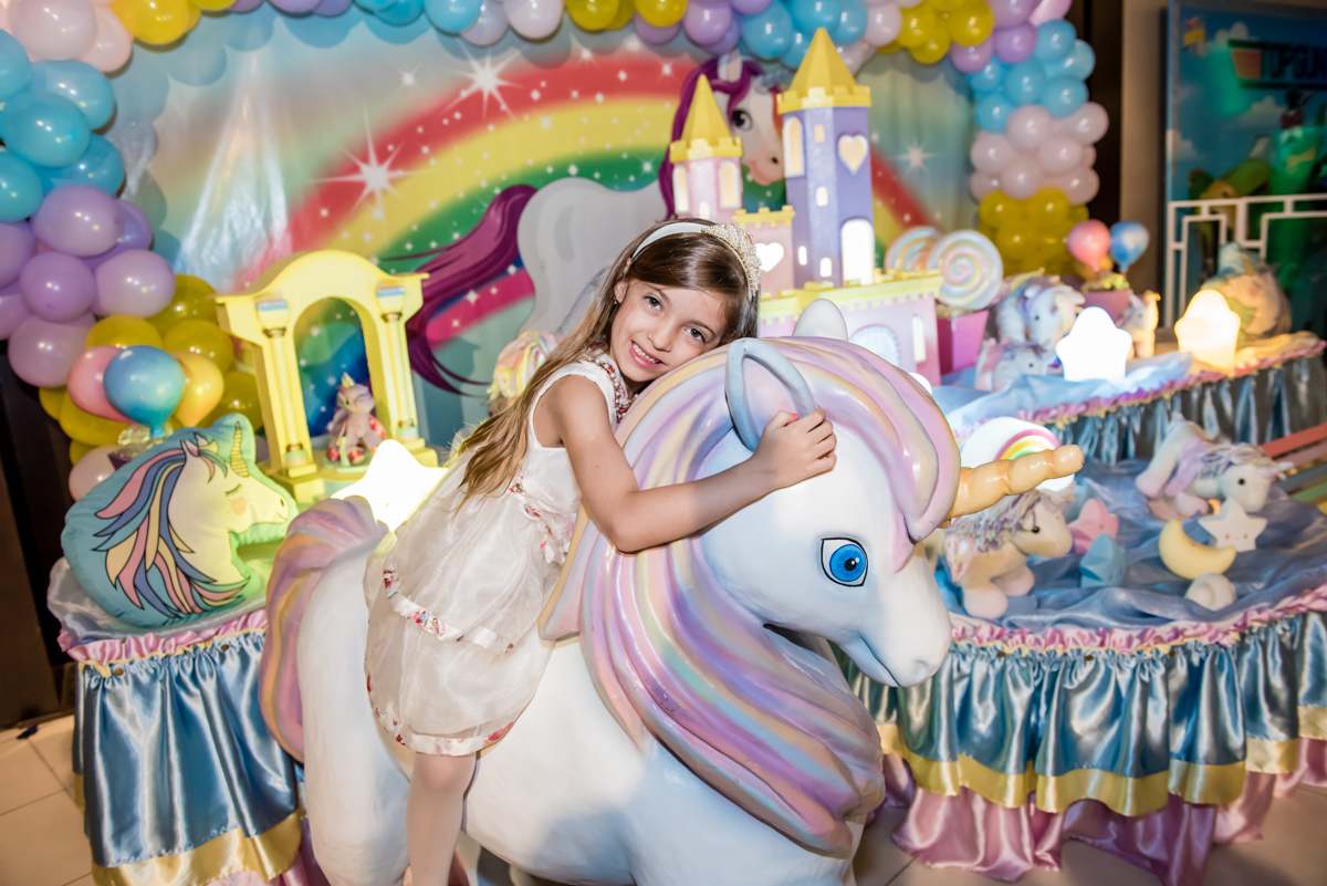 sentada no unicornio muito feliz