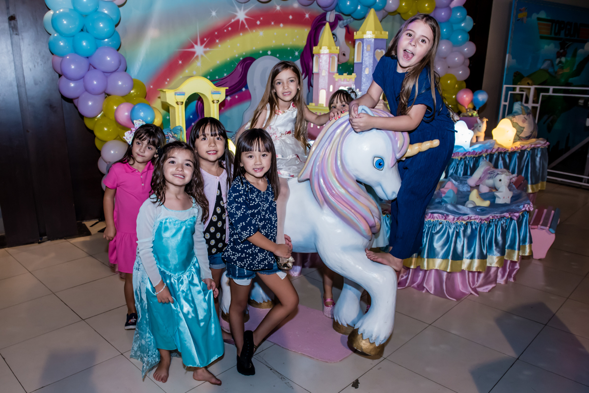 as amigas abraçam o unicornio para mais uma foto