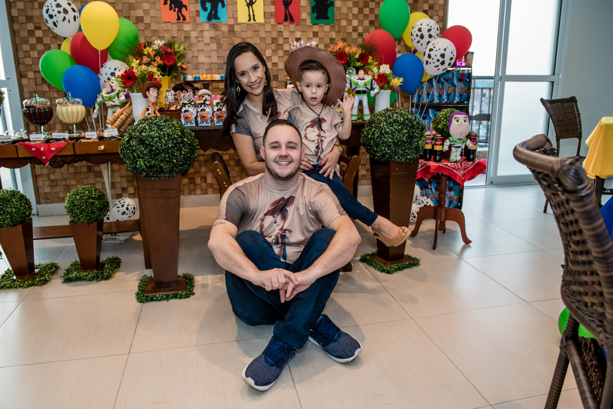 a familia feliz posam para a foto na mesa temática toy story