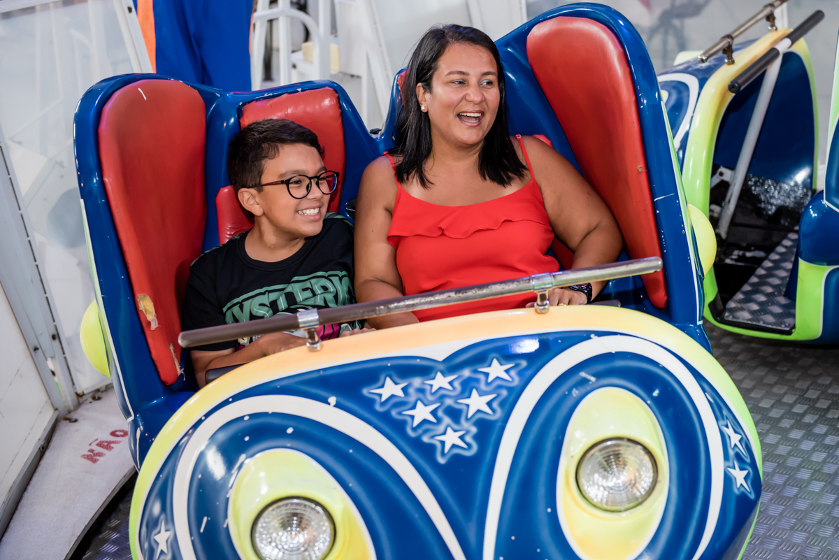 mãe e filho se divertem brincando no brinquedo jornada nas estrelas
