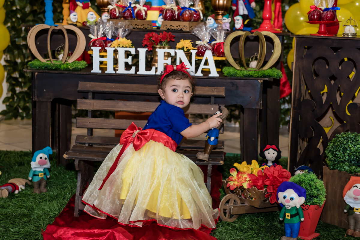 sapeca com uma criança de 1 ano helena mexe nos anões que decoram a mesa