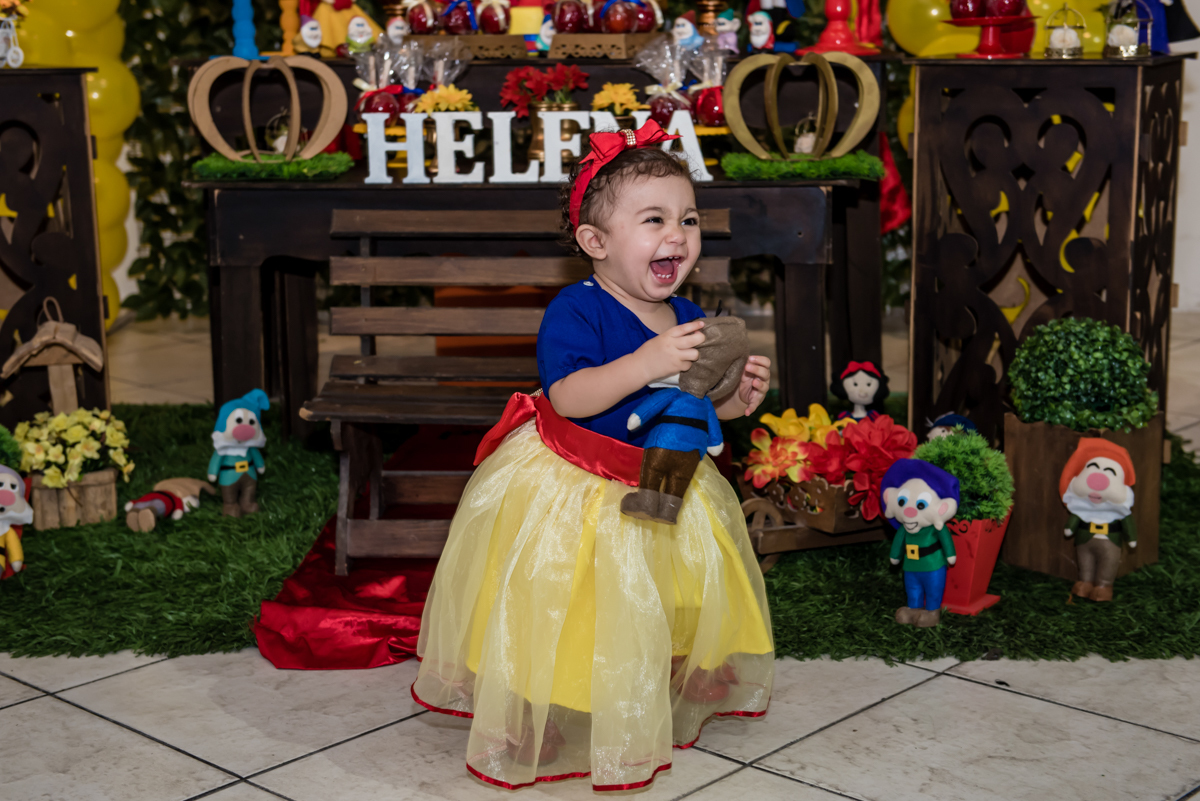 dando gargalhada ao pegar um brinquedo da mesa